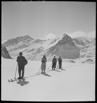 Vier Alpinisten vor Berggipfel