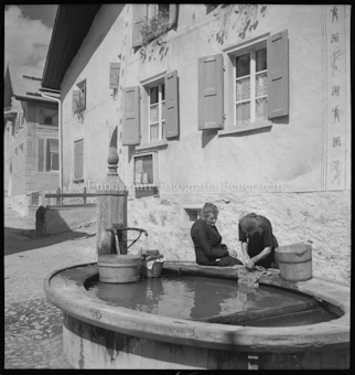 Dorfmotiv aus Guarda, zwei Waschfrauen am Brunnen
