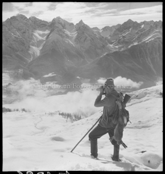 Jäger mit erlegtem Hasen in verschneiter Berglandschaft