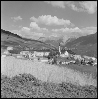 Dorfansicht, davor Getreidefeld