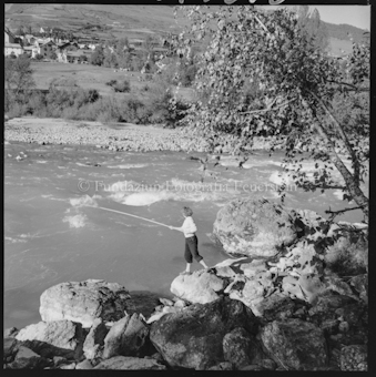 Frau mit Angelrute an Bach