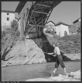 Frau mit Angelrute an Bach