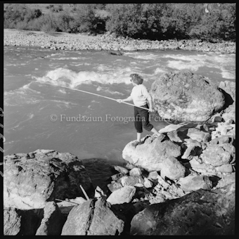 Frau mit Angelrute an Bach