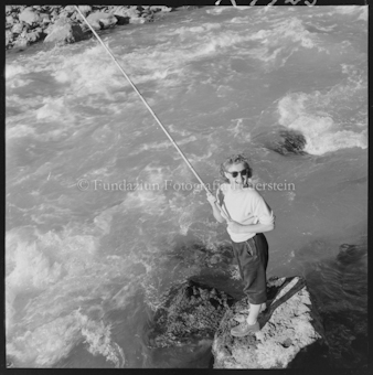 Frau mit Angelrute an Bach