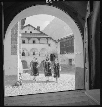 Scuol, drei Engadinerinnen beim alten Kloster, Torbogen