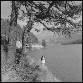 Frau an Seeufer stehend