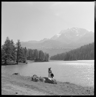 Frau an Seeufer sitzend