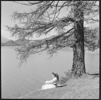 Frau an Seeufer sitzend