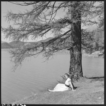 Frau an Seeufer sitzend