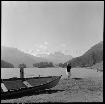 Frau an Seeufer stehend, Boot