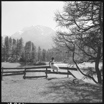 Frau auf Zaun sitzend