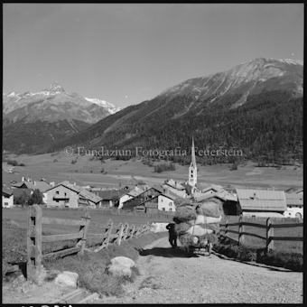 Blick auf Dorf mit Heuwagen