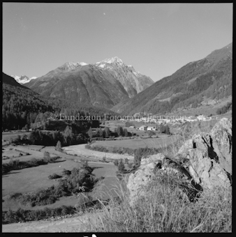Fluss durch BergTal, entfernt sichtbares Dorf 