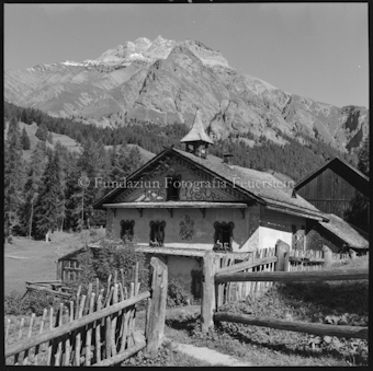 Haus mit Dachreiter vor Berg
