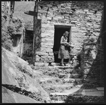 Junge Frau vor Steinhaus