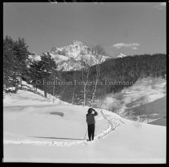 Frau mit Ski in verschneiter Berglandschaft