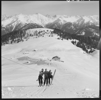 Drei Personen an Skilift