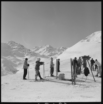 Personen mit Ski an Skilift