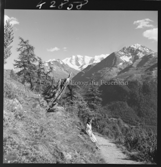 Frau auf Wanderweg vor Bergen