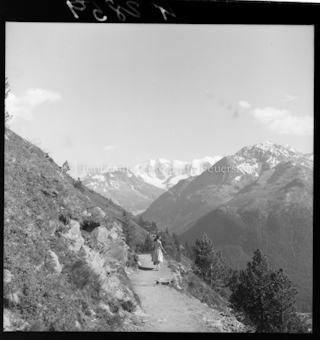 Frau auf Wanderweg vor Bergen