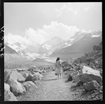 Frau auf Wanderweg vor Bergen