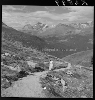Frau auf Wanderweg vor Bergen