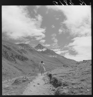 Frau auf Wanderweg vor Bergen