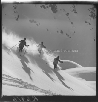 Drei Skifahrer im Neuschnee