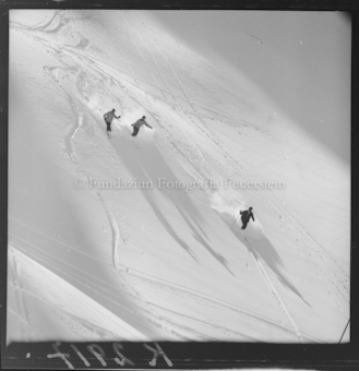 Drei Skifahrer im Neuschnee