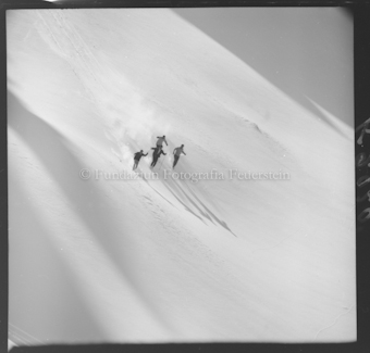 Vier Skifahrer im Neuschnee