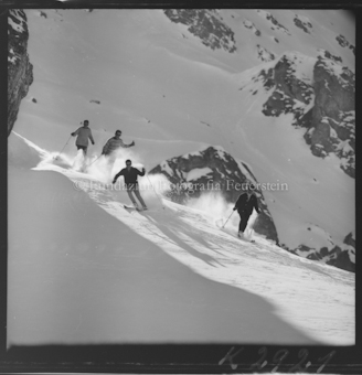 Vier Skifahrer im Neuschnee
