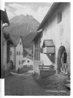 Dorfgasse, Berggipfel im Hintergrund