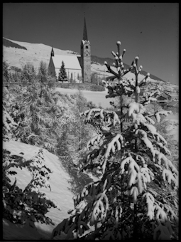 Scuol. Winterlandschaft, im Hintergrund Kirche