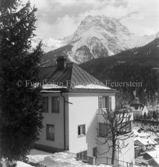 verschneite Landschaft, Nadelbaum im Vordergrund, Scuol, Bezeichnung Hülle: Dr. Enderli, Haus im Winter