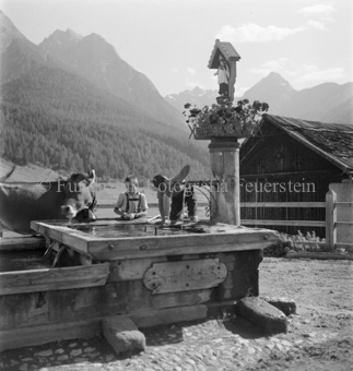 Kind trinkt, Berglandschaft im Hintergrund, Tarasp, Bezeichnung Hülle: Motive Sommer / Winter