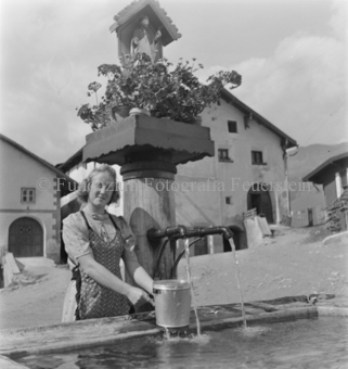 Blumen und Heiligenschrein auf dem Brunnen, Häuser im Hintergrund, Tarasp, Bezeichnung Hülle: Motive Sommer / Winter