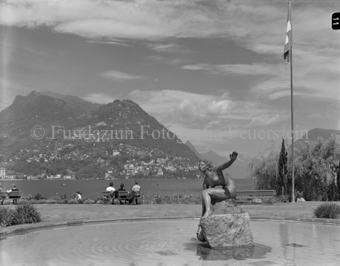 Personen sitzen auf Bänken am See, Bezeichnung Hülle: Lugano