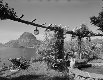 Person im Liegestuhl, Amphore beim Brunnen, Luganersee, Bezeichnung Hülle: 1961 [Tessin]