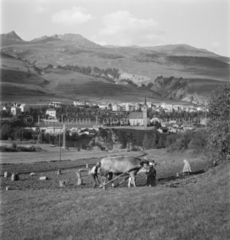 Scuol mit Kirche im Hintergrund, Bezeichnung Hülle: Bauern, Alltag, Brauchtum, Ernte / tagl. Brot / Bauernarbeit / Alpfahrt