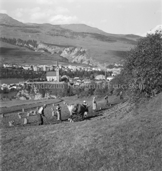 Scuol mit Kirche im Hintergrund, Bezeichnung Hülle: Bauern, Alltag, Brauchtum, Ernte / tagl. Brot / Bauernarbeit / Alpfahrt