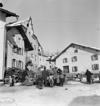Holz und Stroh auf Dorfplatz vor Restaurant Helvetia, Erwachsene und Kinder