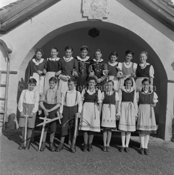 Gruppenfoto in historischen Kostümen, Mädchen in Trachten, Jungen mit Holzwaffen