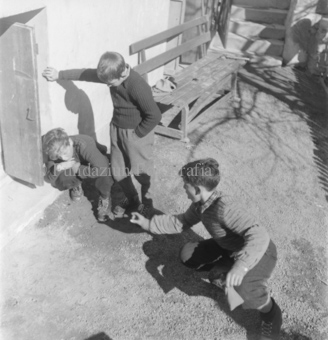 Drei Kinder draussen mit Knöpfen spielend