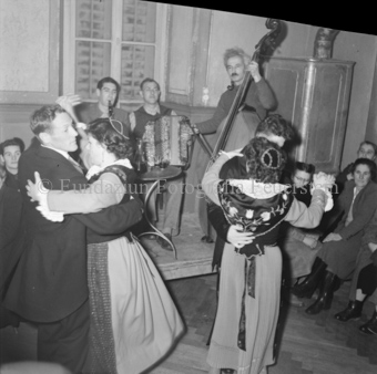 Tanzpaare, dahinter Musiker mit Handorgel, Kontrabass und Klarinette