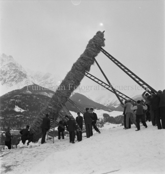 Männer richten mit Leitern den Strohmann ausserhalb vom Dorf auf