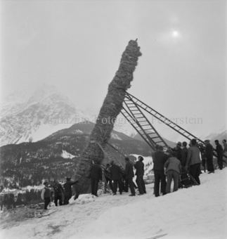 Männer richten mit Leitern den Strohmann ausserhalb vom Dorf auf
