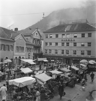 Marktstände und Besucher auf Platz, «Globus» und «Neue Bündner Zeitung» im Hintergrund