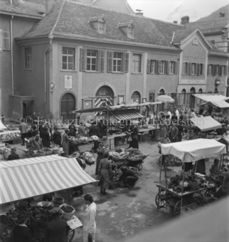 Marktwagen zwischen Ständen auf Platz, Besucher