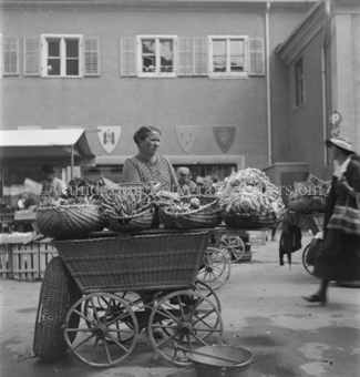 Marktwagen mit Gemüsekörben, Verkäuferin