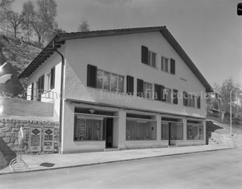 Haus Coiffeur Müller, Foto Feuerstein-Vitrine mit Bildern und Kamera neben anderen Schaufenstern